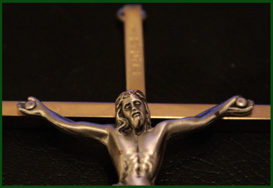 metal crucifix on black background